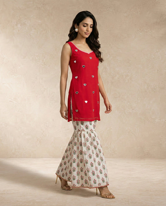 SANA red sleeveless kurti with heart mirror motifs over an ivory floral printed gharara.