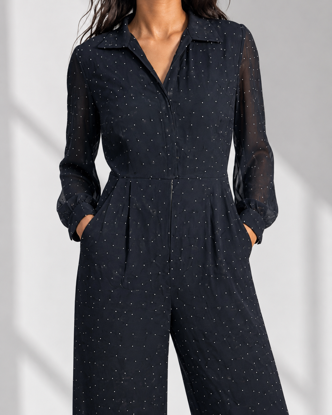 Close view of the collar, front zip and sheer sleeve on the SEVERINE navy dot jumpsuit.