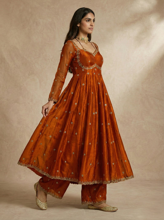 MEHRIN rust anarkali with gold embroidered sweetheart neckline by Neha Sharma Label.