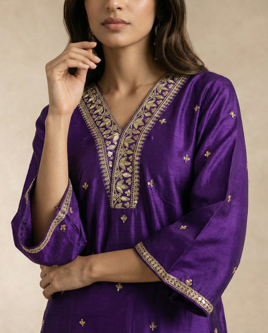 BANAFSHA purple silk kurta with gold zari neckline band and bell cuffs by Neha Sharma Label.