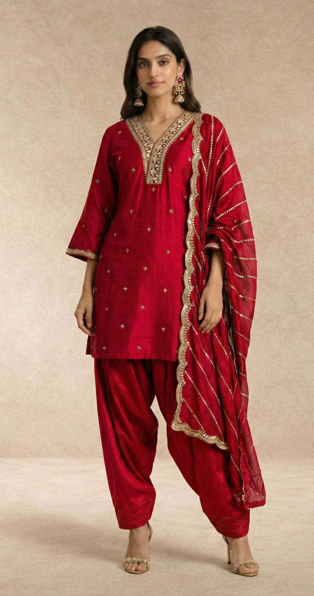 FARHEEN crimson silk kurta with gold zari neckline band and bell cuffs by Neha Sharma Label.