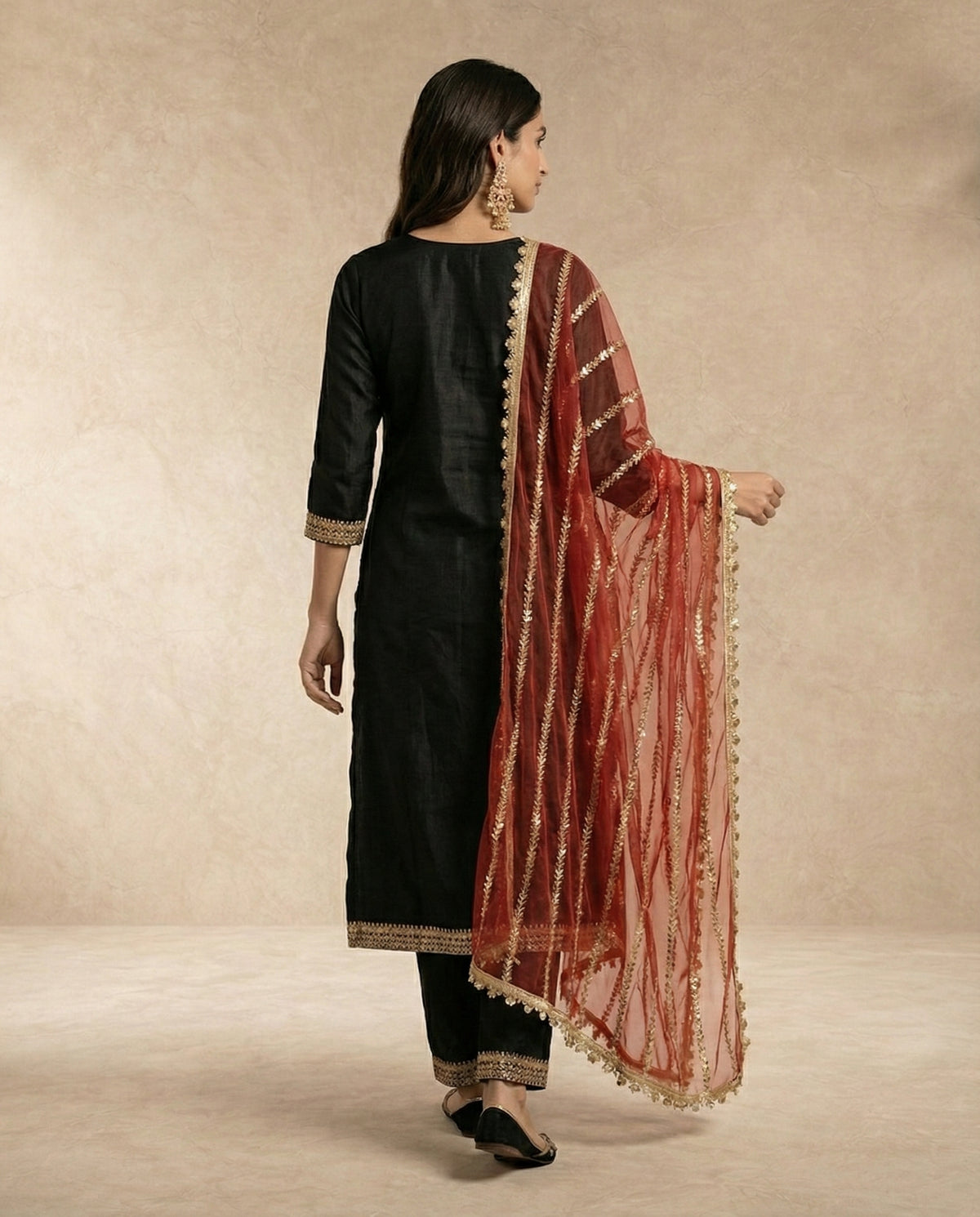 Back view of the NOORI black kurta showing the plain back and gold lace hem border.