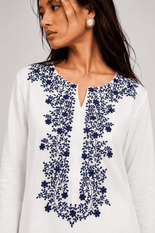 SUNSPELL white cotton kurta with navy floral vine embroidery and notched neckline by Neha Sharma Label.