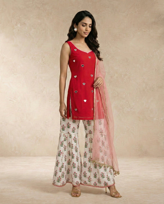 Neha Sharma Label SANA red mirror work kurti with floral printed gharara and sheer pink dupatta.