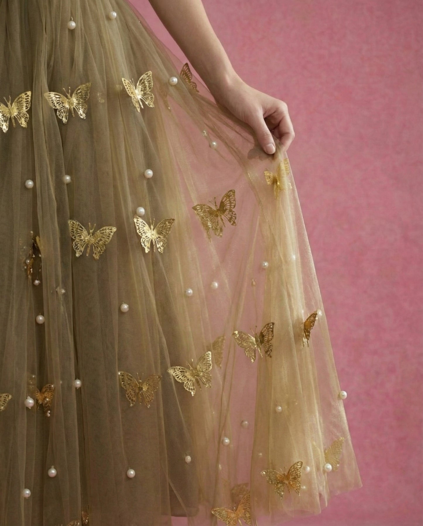 Model wearing SOREN, an ankle-length olive tulle gown with gold metal butterflies and pearls