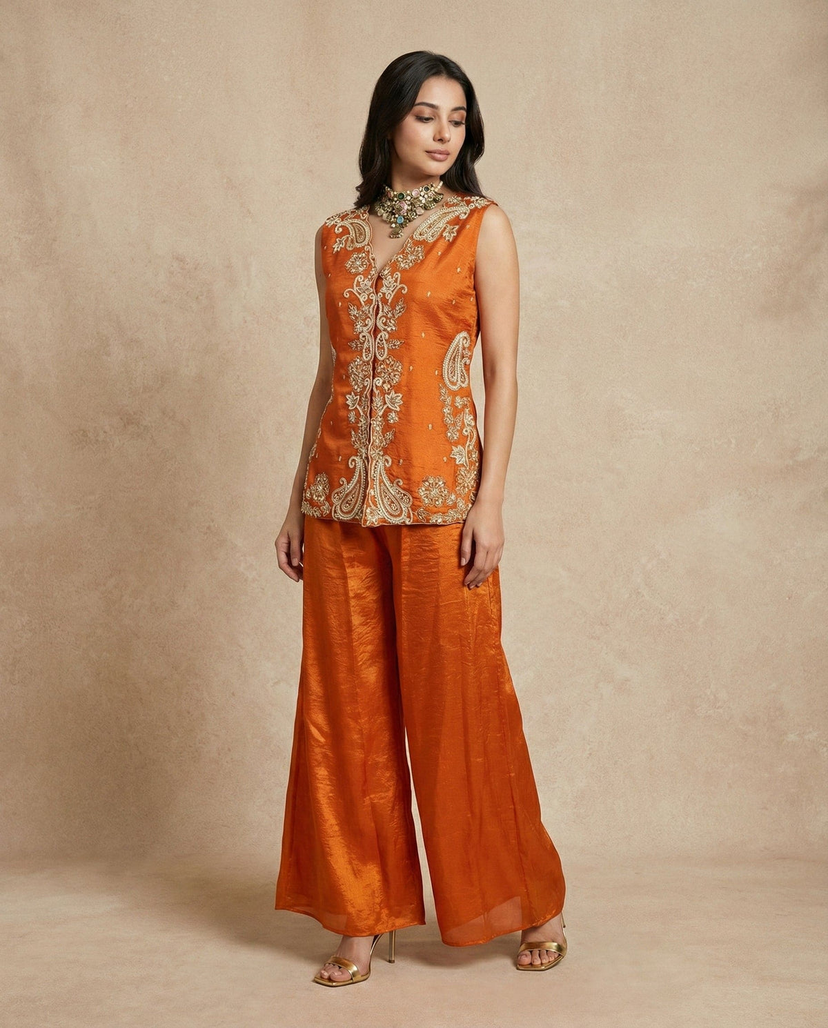 Close view of the hand-embroidered pearl-bead and gold paisley placket on the SHAHNAZ rust silk top.