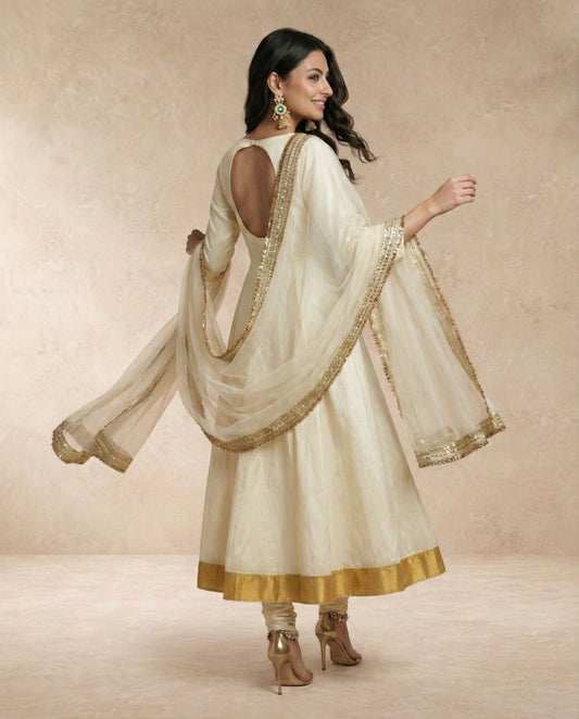 Model wearing ANJUM ivory silk anarkali with flowing organza dupatta by Neha Sharma Label, front view.