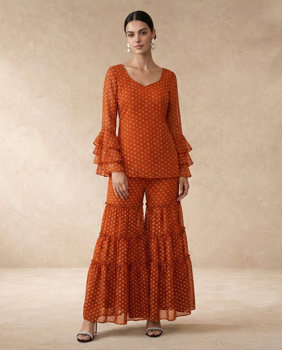 AMBER rust bandhani kurta and tiered sharara with triple-tier ruffle sleeves.