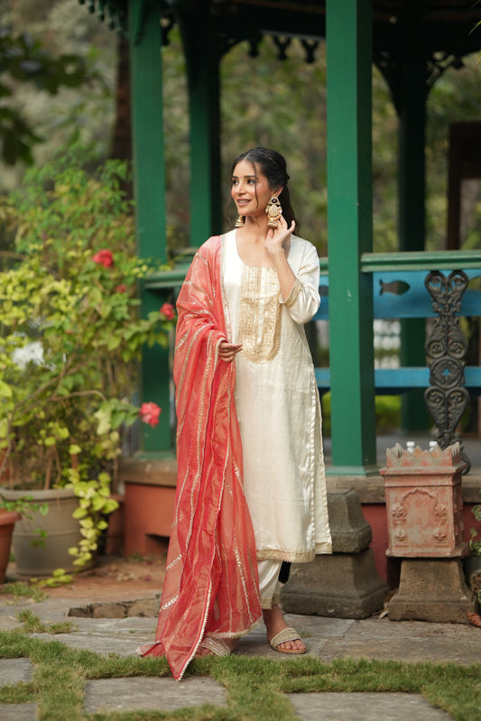 Off white silk kurta with a machine embroidered neckline and a sheer vermilion dupatta.