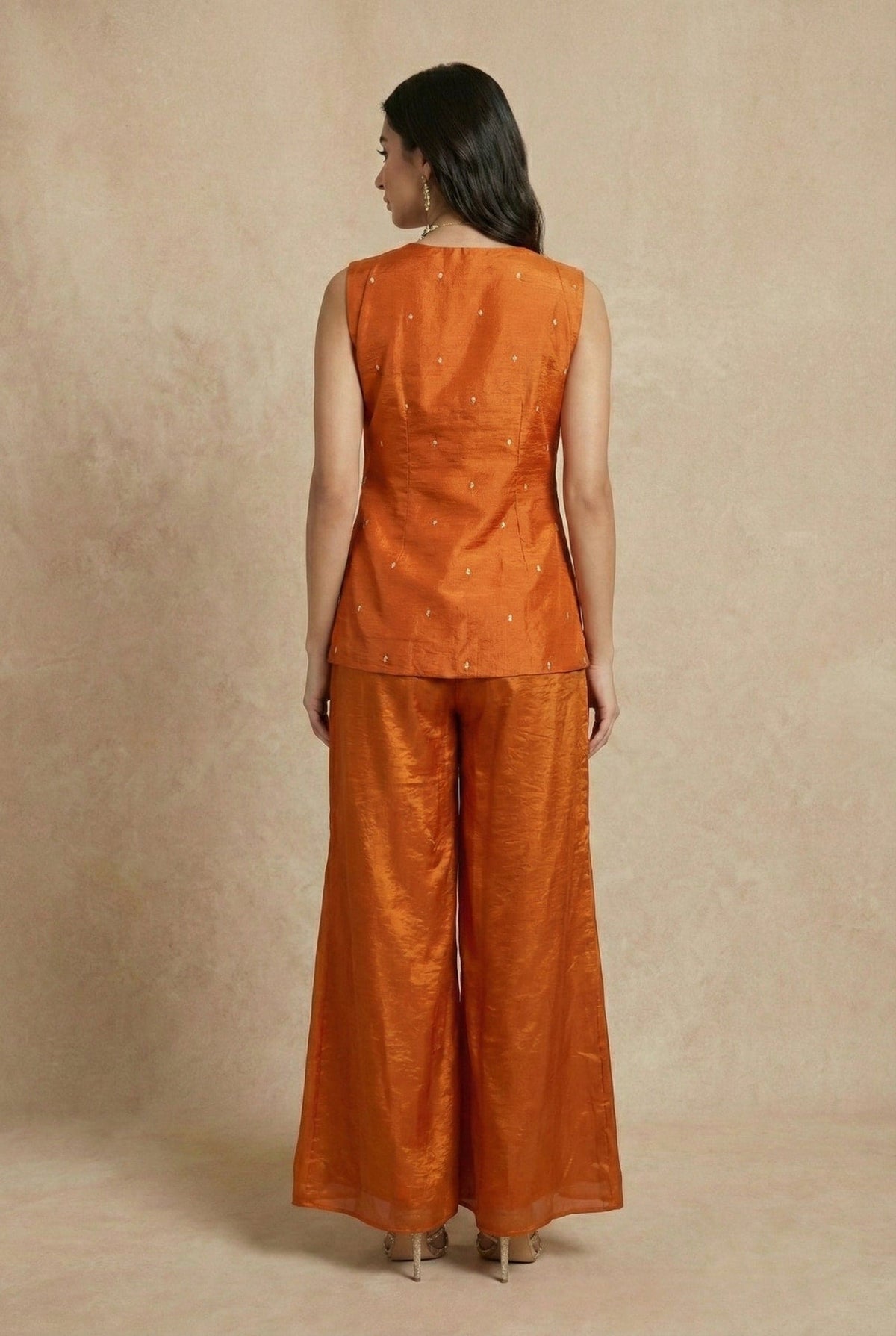 Back view of the SHAHNAZ rust silk sleeveless top and wide-leg pants by Neha Sharma Label.