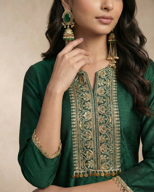 Close view of the ZAREEN embroidered centre bib and its gold coin fringe on bottle green silk.