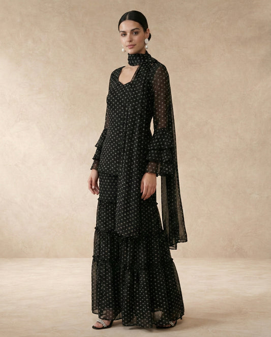 RUKSAR black bandhani print georgette sharara set with sweetheart neck and ruffle bell sleeves.