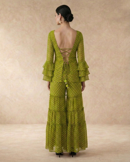 Back view of NAVYA green sharara set with criss-cross lace-up doori back and green pom-pom ties.