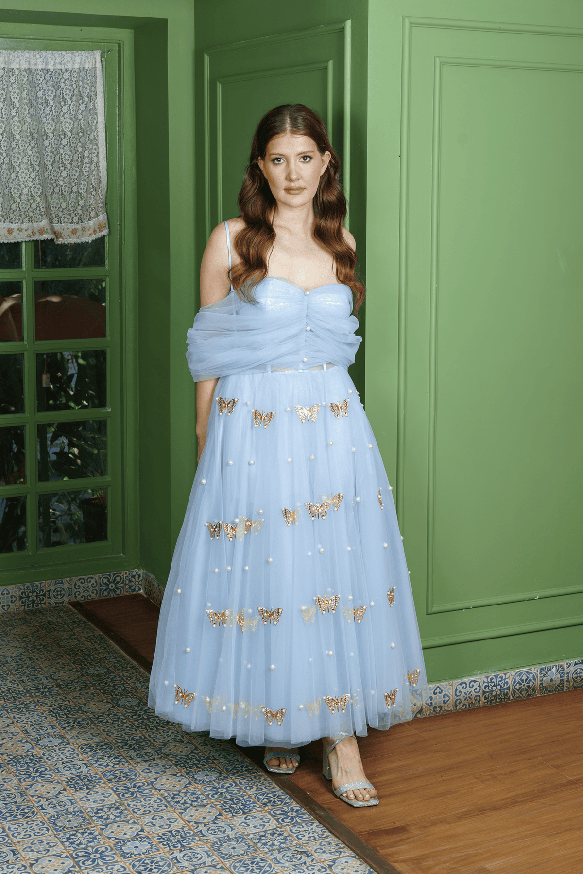 Model wearing Butterfly Pearl powder blue tulle gown with pearl-button ruched bodice