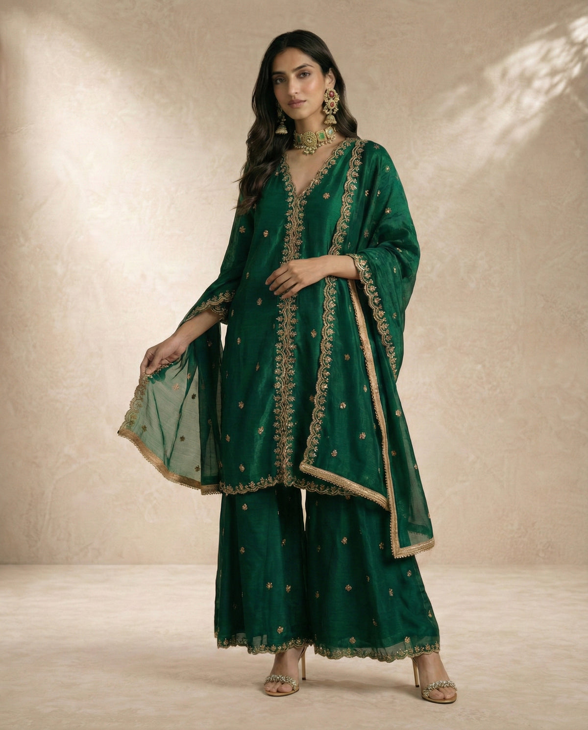 Ferdos deep emerald tissue silk sharara set with all-over gold cheeta embroidery and scalloped borders.