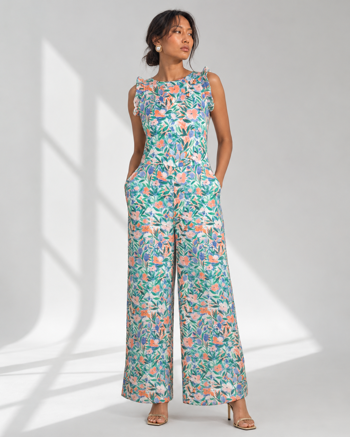 FLEUR jumpsuit in the white garden floral colourway with shoulder ruffles, front view on model.
