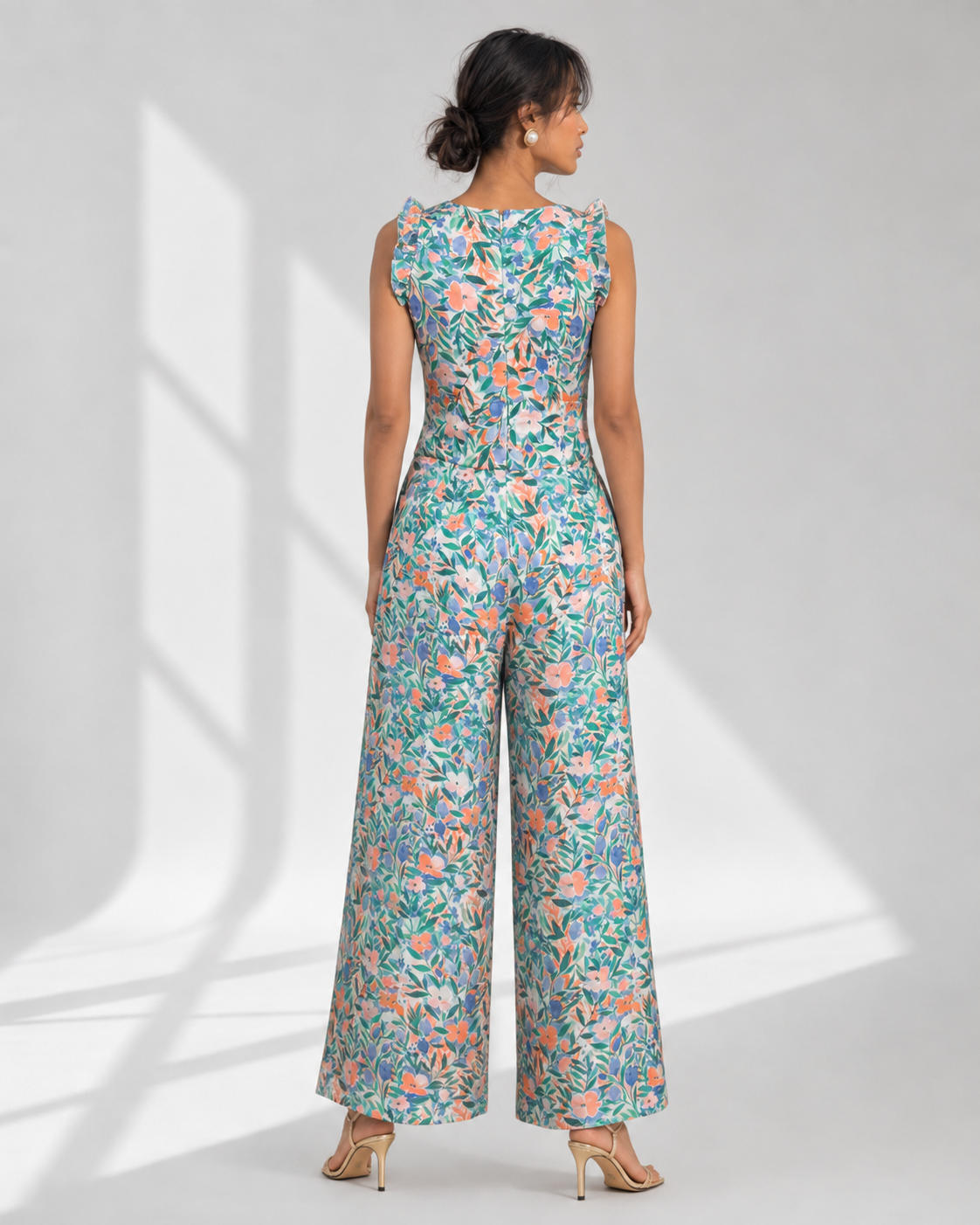 Back view of the FLEUR white garden floral jumpsuit showing the fitted bodice and wide legs.