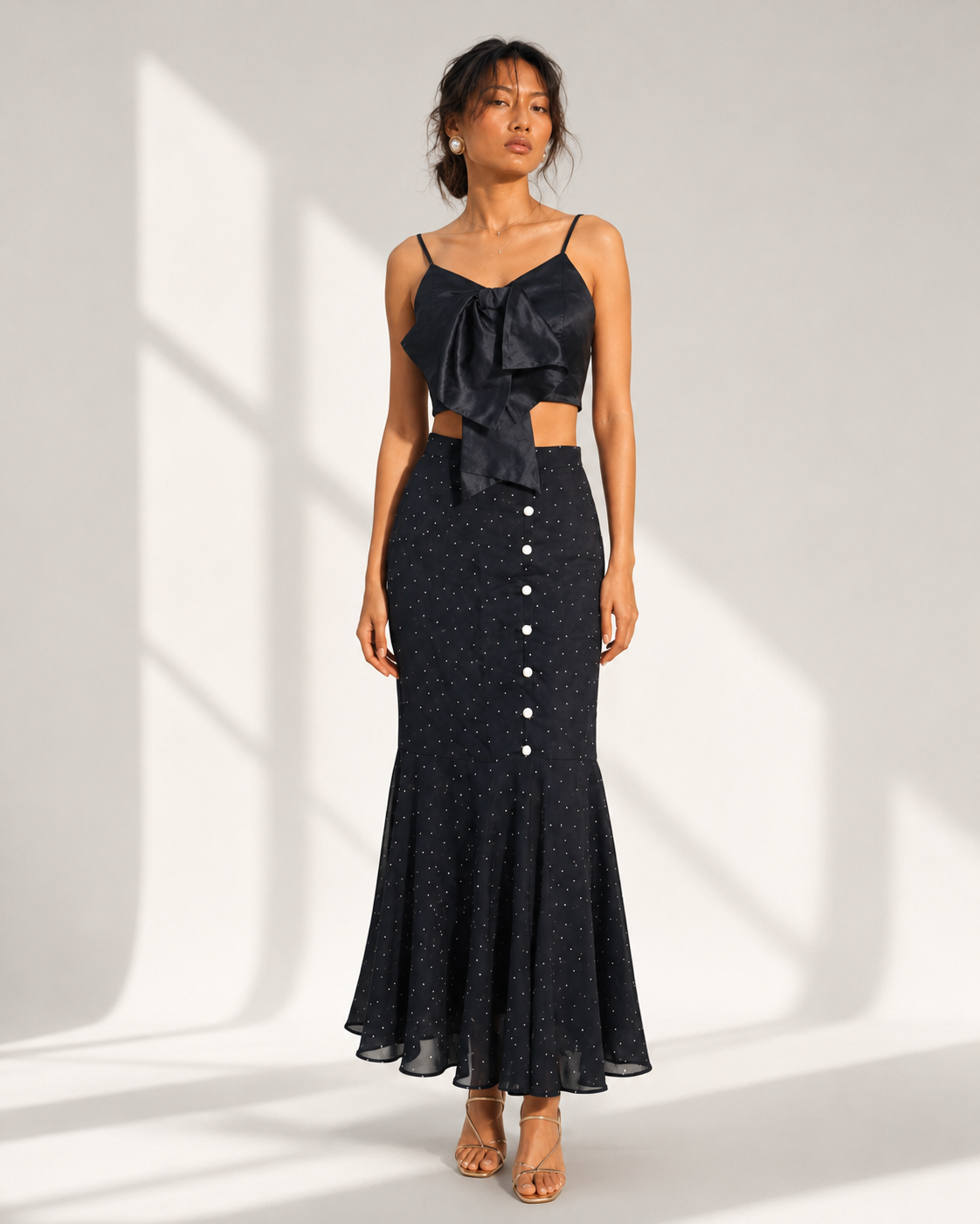Neha Sharma Label FIAMMETTA black micro dot mermaid skirt worn with the matching bow top, front view.