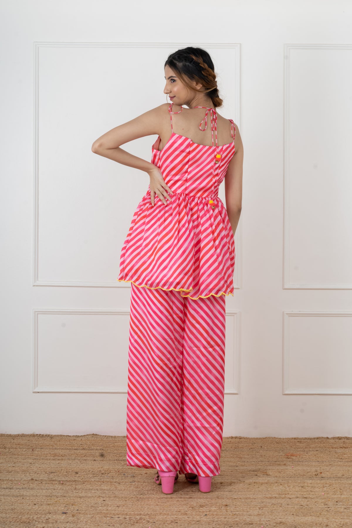 Paakhi pink leheriya mirror flap kurta set with yellow pom-pom tassels.