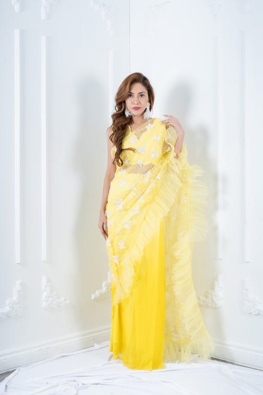 Front view of yellow designer saree with butterfly drape and ruffle border.
